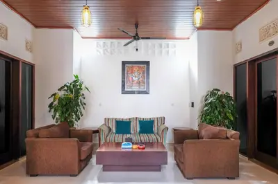 a living room with two chairs and a coffee table at Urbanview Hotel Arta Guna Casa in Kerobokan