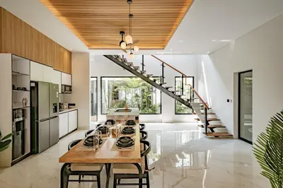 a kitchen with a long table and a staircase at Aya Townhouses - Prime Location Umalas in Kerobokan