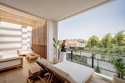 a woman standing on top of a balcony with a view at Aya Townhouses - Prime Location Umalas in Kerobokan