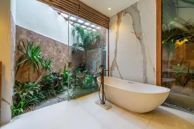 a bath tub in a bathroom with plants at Sweet Surrender - Stylish 4BR Near Potato Head in Seminyak