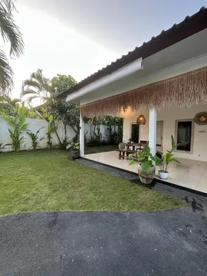 a house with a patio and a grass yard at Kondo Villa 2 BR- Private Pool in Seminyak