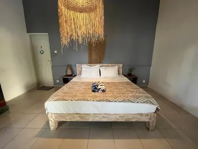 a bedroom with a bed with a pair of shoes on it at Kondo Villa 2 BR- Private Pool in Seminyak