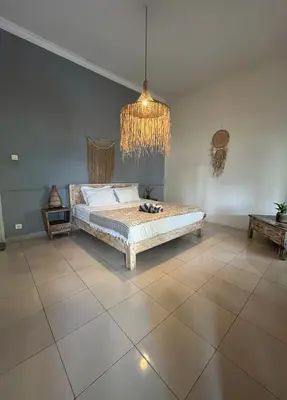 a bedroom with a bed and a chandelier at Kondo Villa 2 BR- Private Pool in Seminyak