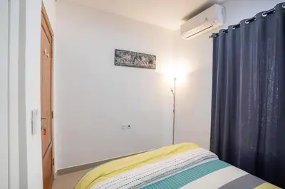 a bedroom with a bed with a blue curtain at Town House, Modern Minimalis, Lokasi Strategis in Seminyak