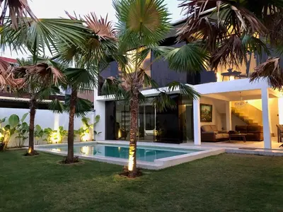 a villa with a swimming pool and palm trees at Villa Denira, Home Gym & Private Pool in Nusa Dua
