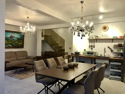 a dining room and living room with a table and chairs at Villa Denira, Home Gym & Private Pool in Nusa Dua