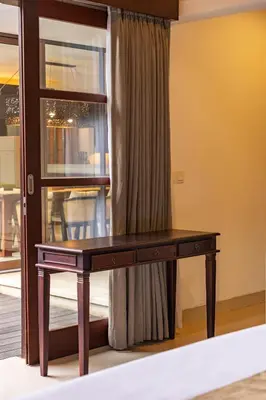a wooden desk sitting in front of a window at Aragreen Berawa Villa in Canggu