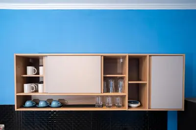 a wooden cabinet with white doors and shelves at Villa De Ocean in Seminyak