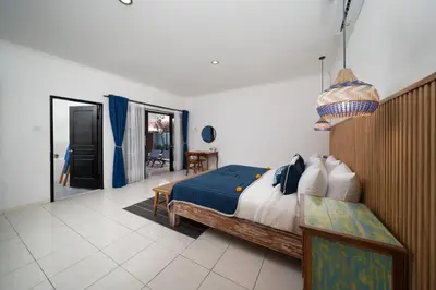 a bedroom with a bed and a table in it at Villa De Ocean in Seminyak