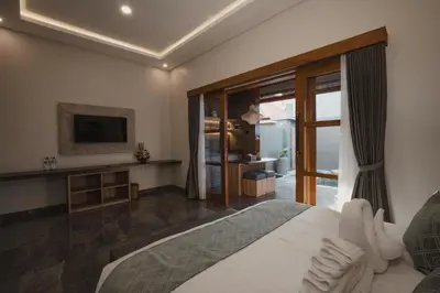 a bedroom with a large bed and a television at Dikubu Belong VILLA in Denpasar