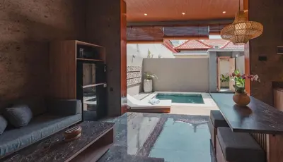 a living room with a couch and a swimming pool at Dikubu Belong VILLA in Denpasar