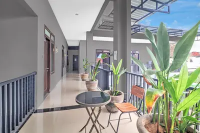 a balcony with plants and a table and chairs at Hotel O near Trans Studio Theme Park formerly Cyloam Residence in Legian