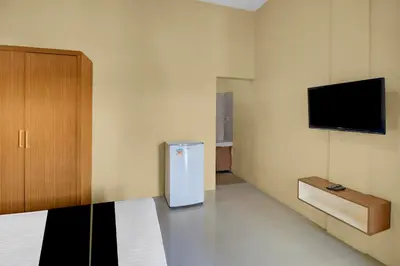 a room with a refrigerator and a tv on the wall at Hotel O near Trans Studio Theme Park formerly Cyloam Residence in Legian