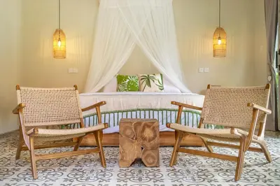 a bedroom with a bed with two chairs and a table at LePalms villa, 2min Beach, 10min Atlas,Finns Club in Canggu