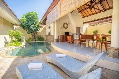 a patio with chairs and a swimming pool at Villa PBC 2 Bed Room Private Pool in Seminyak in Seminyak