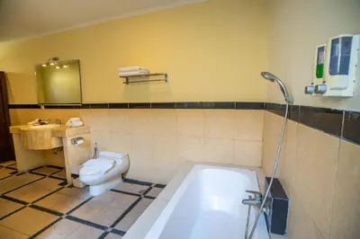 a bathroom with a tub and a toilet and a sink at Villa PBC 2 Bed Room Private Pool in Seminyak in Seminyak