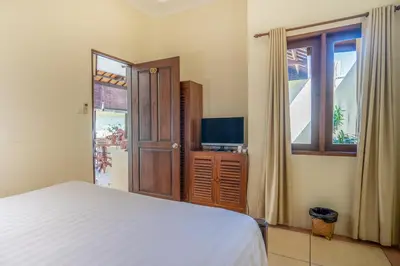 a bedroom with a bed and a tv and a window at Villa PBC 2 Bed Room Private Pool in Seminyak in Seminyak
