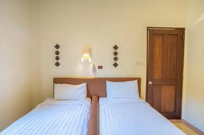 two beds in a small room with a door at Clasic 3BRoom Villa In Seminyak in Seminyak