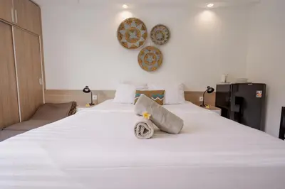 a bedroom with a large white bed with towels on it at Homely Bali at Rajapala in Seminyak