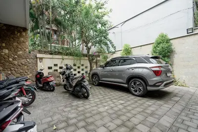 a suv parked in a parking lot next to motorcycles at Homely Bali at Rajapala in Seminyak