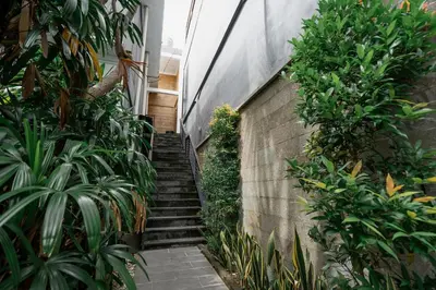 a staircase leading up to a building with plants at Homely Bali at Rajapala in Seminyak