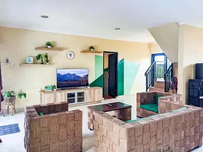 a living room with a couch and a tv at The Lavana Villa Singgahan Jimbaran - 3 Bedroom Villa in Nusa Dua