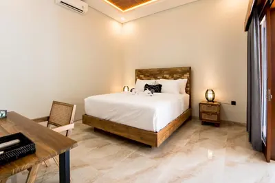 a bedroom with a large bed and a desk at Villa Sakura ll seminyak in Seminyak