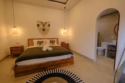 a bedroom with a bed and a bathroom at New Vindra I Villa 2BR in the heart of Berawa in Canggu