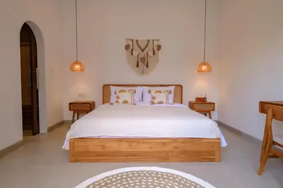 a bedroom with a large bed with white sheets at New Vindra I Villa 2BR in the heart of Berawa in Canggu
