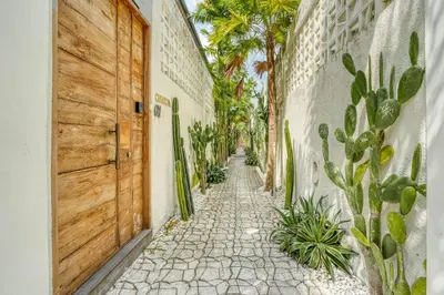 an alley with a wooden door and cactus at Casa De Fiero A4 2BR Villa In Seminyak in Seminyak