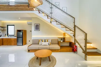 a living room with a couch and stairs at Casa De Fiero A4 2BR Villa In Seminyak in Seminyak
