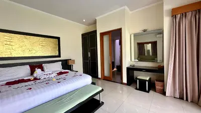 a bedroom with a large bed and a mirror at 1 Bed Room Private Pool Villa in Seminyak - PBM1 in Seminyak