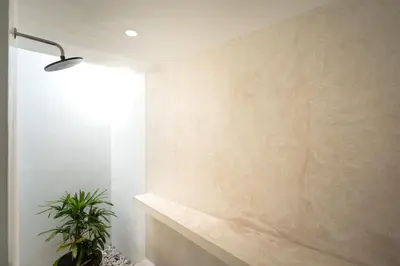 a room with a concrete wall and a potted plant at Villa Tara in Seminyak
