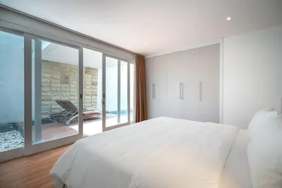 a bedroom with a large white bed and a large window at Villa Tara in Seminyak