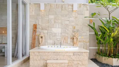 a bathroom with a sink and a stone wall at Villa Larimar by Villa Finder in Legian