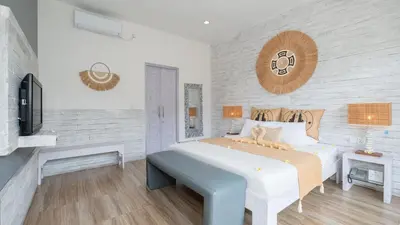 a bedroom with a large bed and a tv at Villa Larimar by Villa Finder in Legian