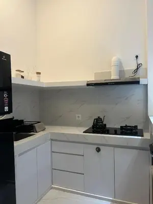 a kitchen with white cabinets and a stove top oven at Klissy Studio Villa in Kerobokan
