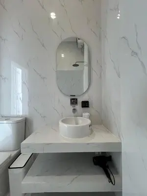 a white bathroom with a sink and a mirror at Klissy Studio Villa in Kerobokan