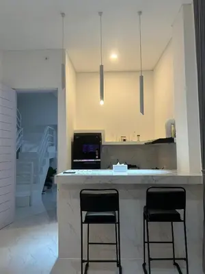 a kitchen with two black stools at a counter at Klissy Studio Villa in Kerobokan