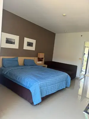a bedroom with a bed with a blue comforter at Cozy Apartement in Seminyak in Uluwatu