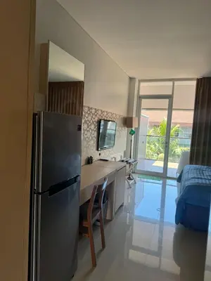 a kitchen with a refrigerator and a desk in a room at Cozy Apartement in Seminyak in Uluwatu