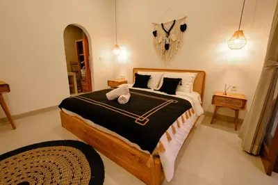 a bedroom with a large bed with black and white sheets at New Vindra II Villa Mediteranian 2BR Canggu in Canggu
