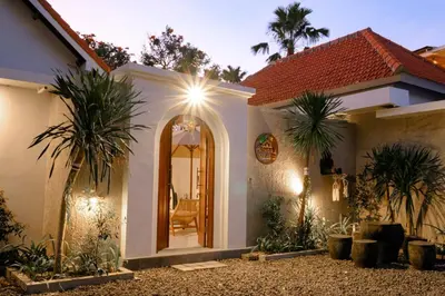 a house with a mirror and palm trees in front of it at New Vindra II Villa Mediteranian 2BR Canggu in Canggu