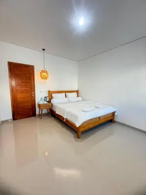 a bedroom with a bed in a white room at Home Stay Room in Bali Near Sanur Beach in Sanur