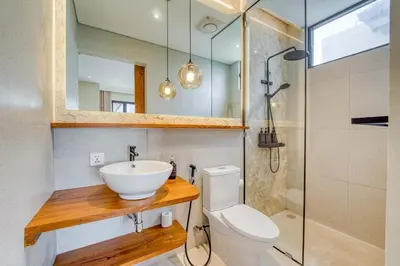 a bathroom with a sink and a toilet and a shower at Casa Amadeo Villas Seminyak in Seminyak