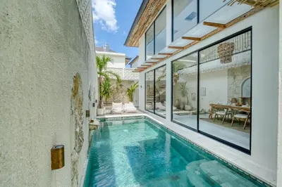 a swimming pool in the middle of a house at Casa Amadeo Villas Seminyak in Seminyak
