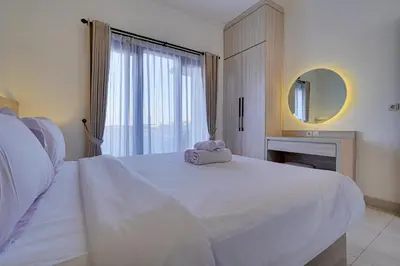 a bedroom with a large white bed with a mirror at Stylish 2BR Villa Taman Seminyak 52 near Beach in Seminyak