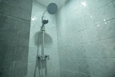 a shower with a shower head in a bathroom at Narmada House Seminyak in Seminyak