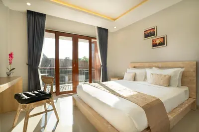 a bedroom with a large bed and a balcony at Narmada House Seminyak in Seminyak