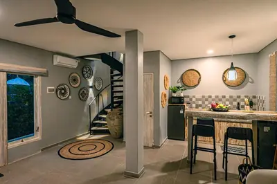 a kitchen with a spiral staircase in a house at Amshiga 1 in Jimbaran
